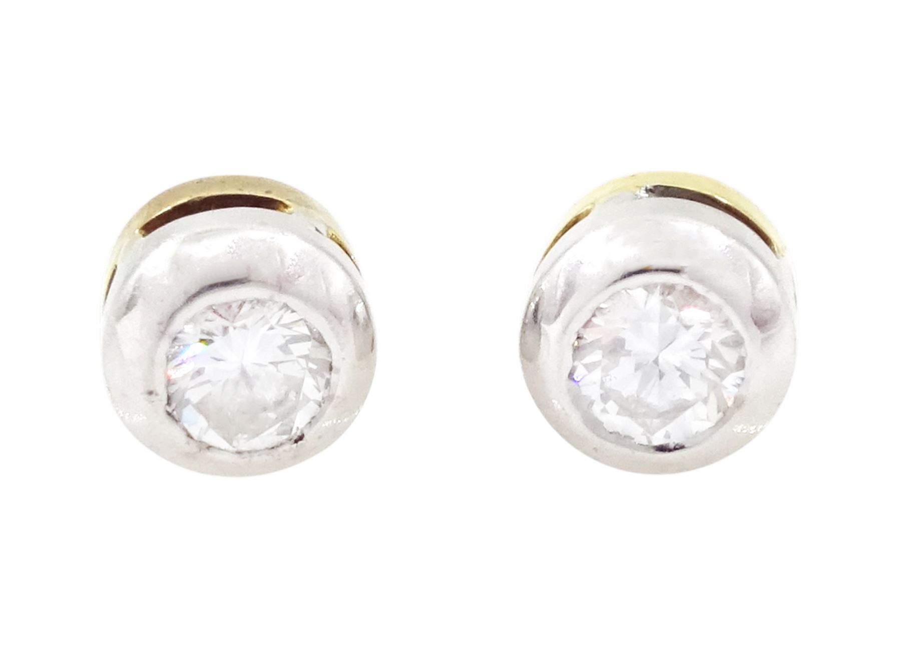 Pair of 18ct white and yellow gold diamond earrings, each stud bezel set with a round brilliant cut diamond, London 1998, total diamond weight 0.25 carat