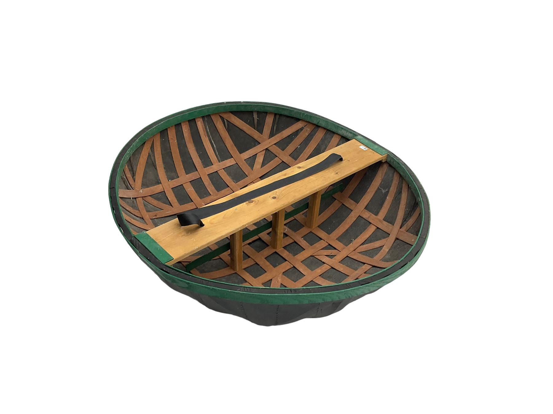Coracle boat, comprised of woven planks and waterproof covering with single plank seat and strap