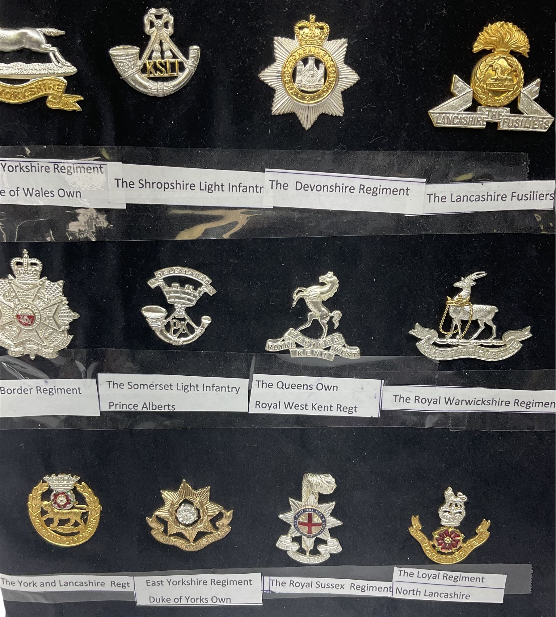 Collection of thirty-two reproduction military badges, including Royal Scots Fusiliers, Royal Lincolnshire Regiment, The Boarders Regiment etc. 