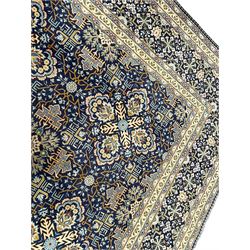 Persian indigo and pale gold ground rug, overall busy geometric design, the field decorated with hooked Hac and palmette medallions surrounded by densely patterned zig-zags and stylised foliate motifs, the border decorated with smaller Hac motifs, within multiple guard stripes 