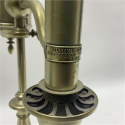 William H Honey polished brass adjustable student's oil lamp, with green glass shade, H60cm