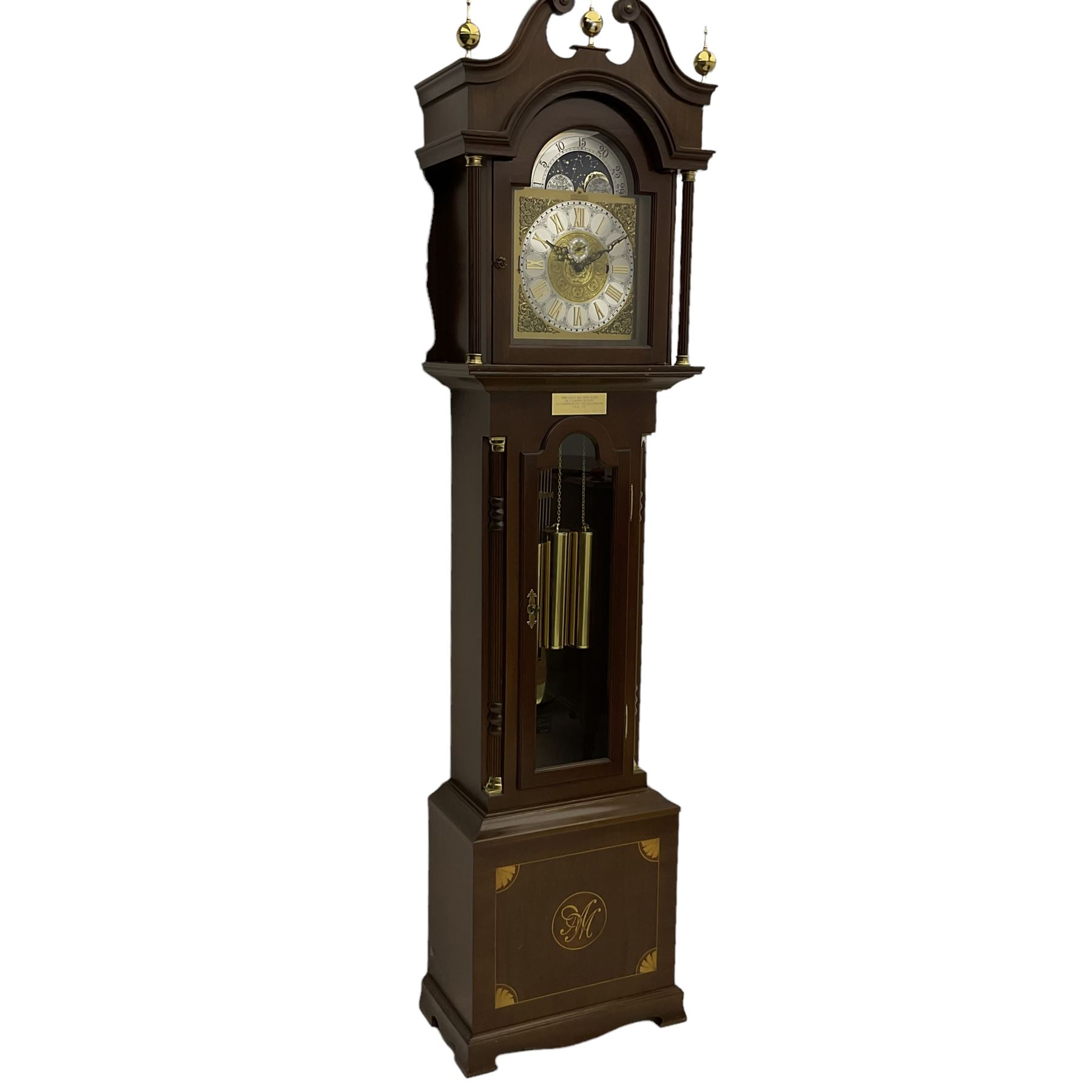 A  20th century longcase clock made to celebrate the millennium in the year 2000, this clock being No 2 of only 200 manufactured by  Richard Broad in Bodmin Cornwall, with a mahogany effect case and traditional swans neck pediment with three brass finials, break arch hood door on a trunk with recessed columns and full length glazed door, on a square plinth with inlay and a shaped base, brass dial with brass spandrels, silvered chapter ring, seconds dial and working moon phase to the arch, weight driven three train movement striking the quarters and hours on 12 gong rods, with a choice of St Michael, Westminster and Wittington chimes, with chime selector and chime/silent facility. With three brass cased weights and gridiron pendulum.





