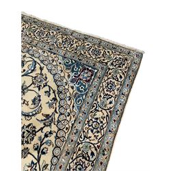 Persian Kashan ivory ground rug, central medallion surrounded by scrolling leafy branches and stylised flowerhead motifs, scrolling border decorated with further stylised plant motifs