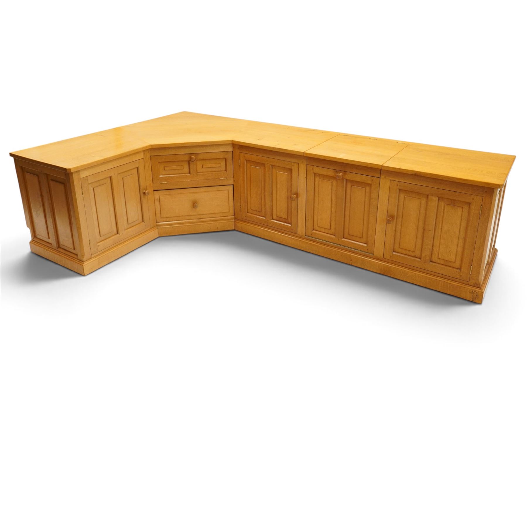 Seahorseman by Shaw & Riley - bespoke large Yorkshire oak corner sideboard or media unit, of L-shape form, with three cupboard doors, a fall front drawer over a regular drawer, a lift up panel for a record player, multiple apertures for wires, raised on a plinth base, with signature Seahorse carving from the workshop of A. Shaw & Riley Ltd, Hessay
