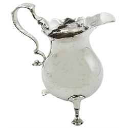 George II silver cream jug, of bellied form with 'frilled' rim, and foliate capped scroll handle, upon three pad feet, hallmarked London 1749, makers mark worn and indistinct, H9.5cm, approximate weight 2.79 ozt (87 grams)