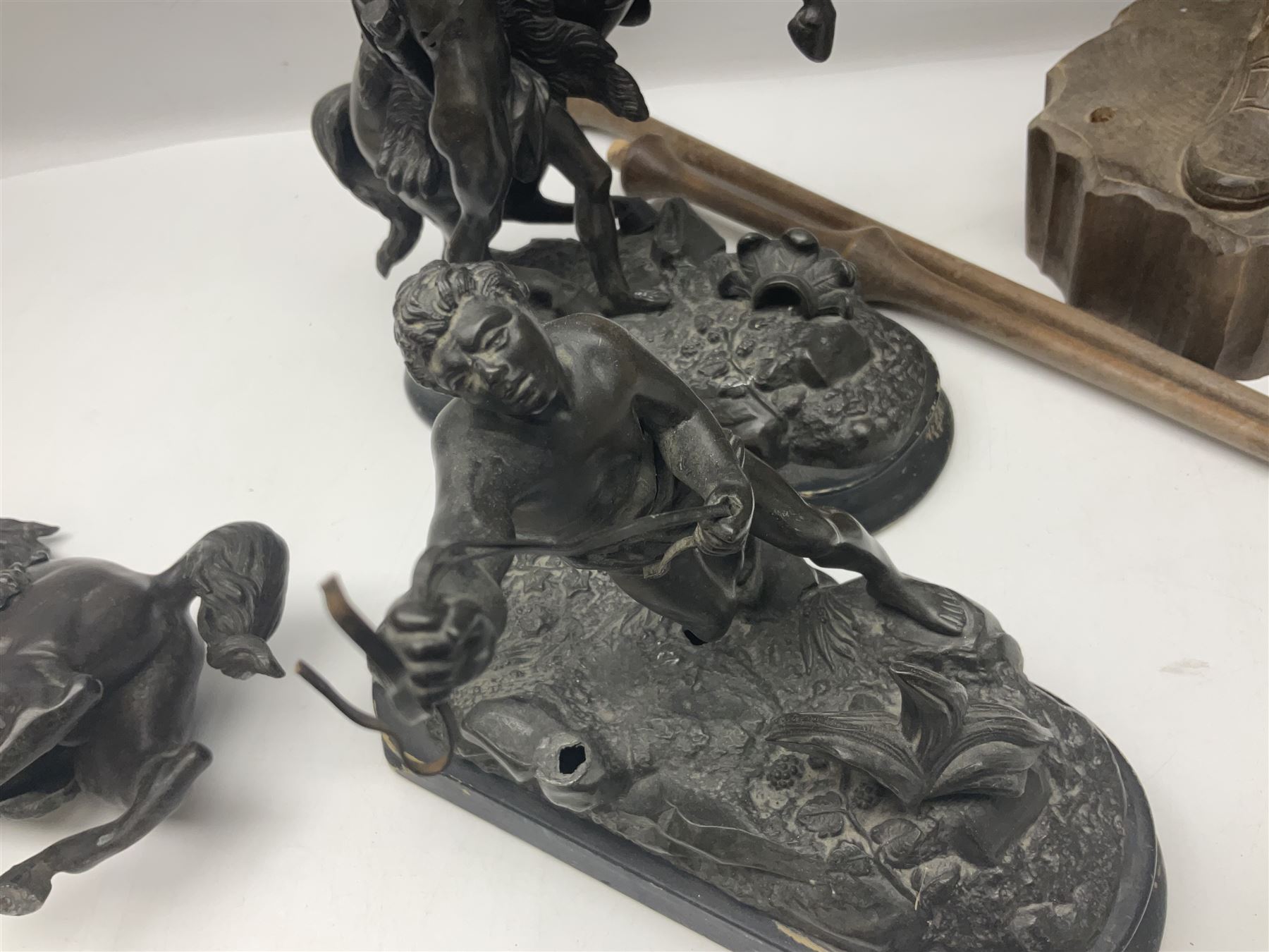 Spanish carved figure of Don Quixote, holding a book, base stamped 'Ouro, together with two spelter figures and one other