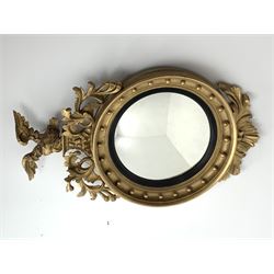 Large Regency carved wood and gesso circular convex mirror, eagle pediment on platform flanked by acanthus leaf scrolls, moulded surround and ebonised slip