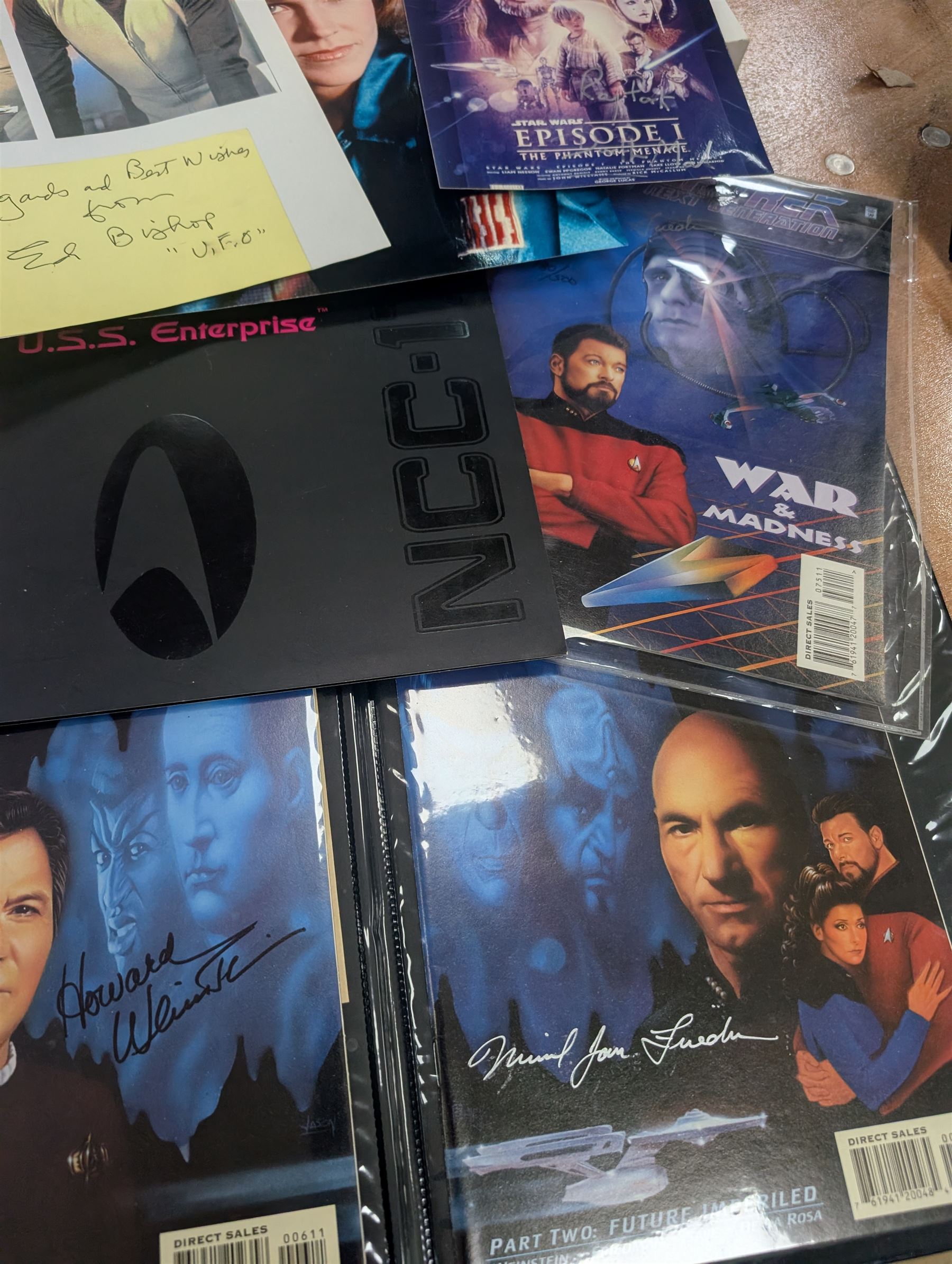 Collection of Star Trek The Next Generation and Deep Space Nine memorabilia, including two limited edition signed Star Trek Deep Space Nine photographs, commemorative porcelain plaque, insignias, Encounter at Farpoint pewter plaque, signed photograph of the Voyager crew, two signed copies of Convergence and a signed War & Madness graphic novel, canvas prints and other signed photos, together with Star Wars Ray Park (Darth Maul) signed photograph, UFO and Buck Rogers memorabilia