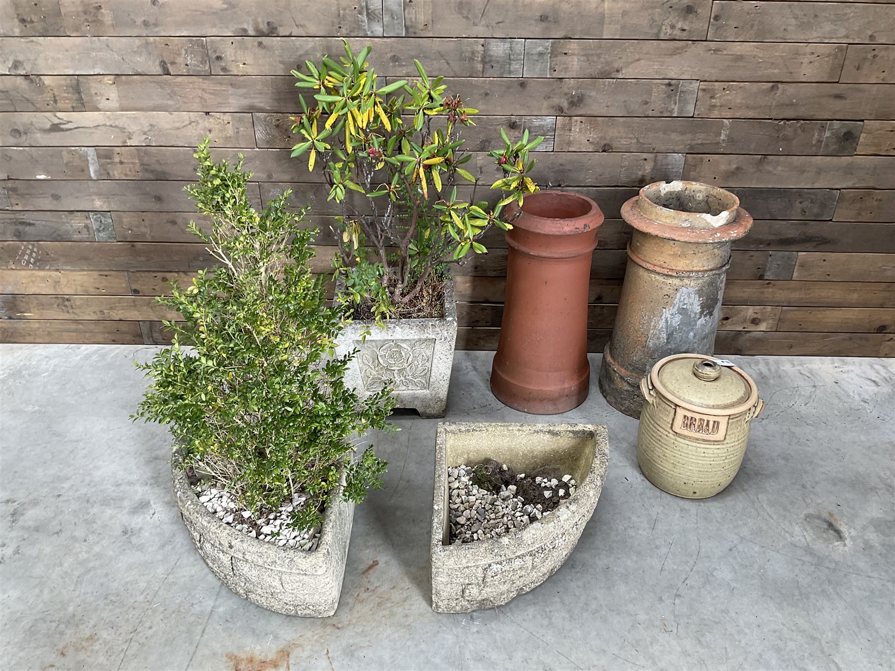 Two cast stone corner planters, square planter other Yorkshire Rose, two terracotta chimney pots and a terracotta bread bin (6)