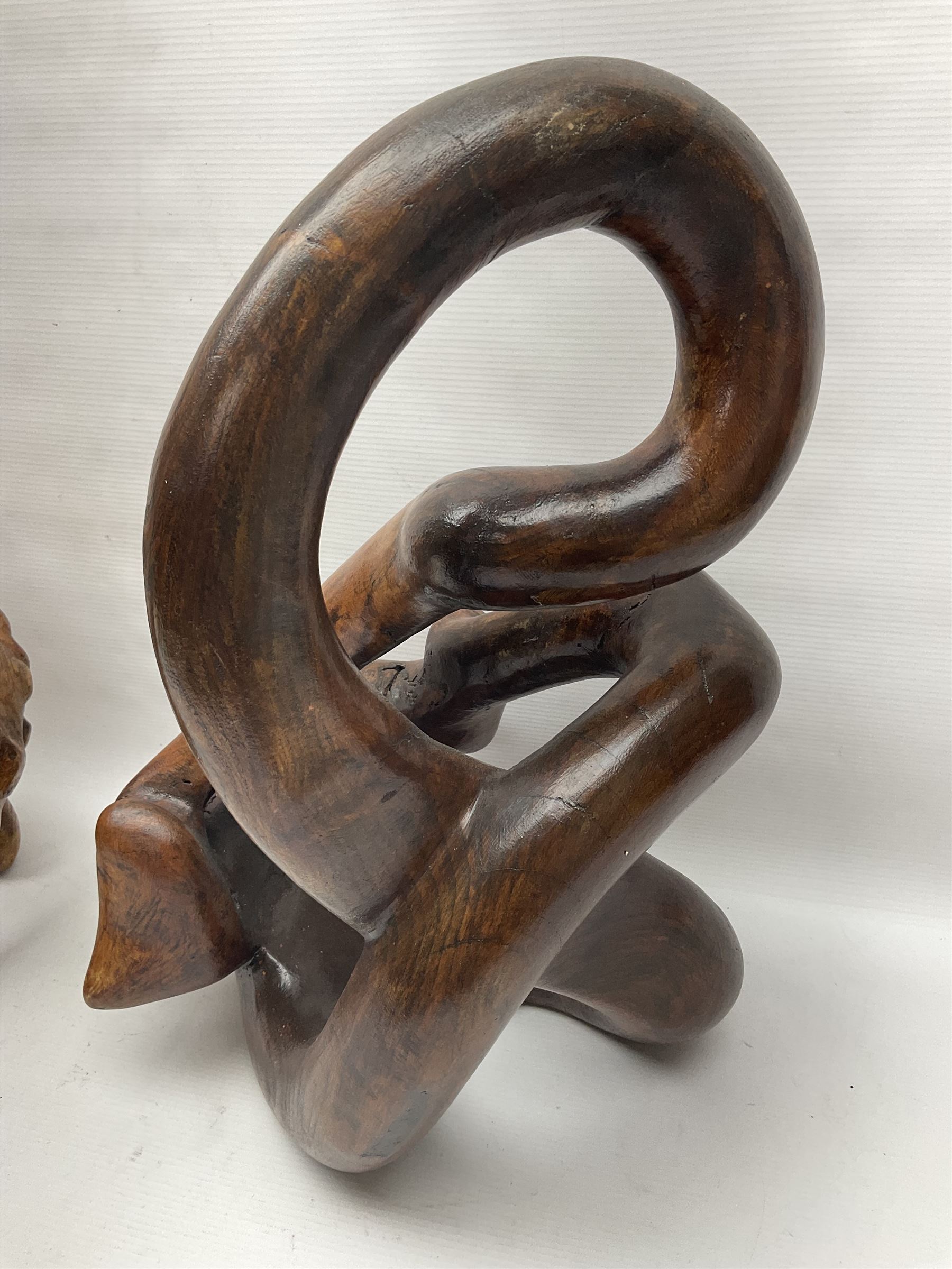 Helen Skelton (British 1933 – 2023): Two carved wooden abstract sculptures, one modelled as a entwined knot, largest H48cm. Born into an RAF family in 1933 in Kent and travelled the world extensively during her childhood. After settling in Bridlington, Helen immersed herself in painting, textiles, and wood sculpture, often inspired by nature's beauty. Her talent was showcased in a one-woman show at Sewerby Hall and recognised with the sculpture prize at Ferens Art Gallery in 2000. Sadly, Helen’s daughter passed away from cancer in 2005. This loss inspired Helen to donate her sculptures to Marie Curie upon her passing in 2023.