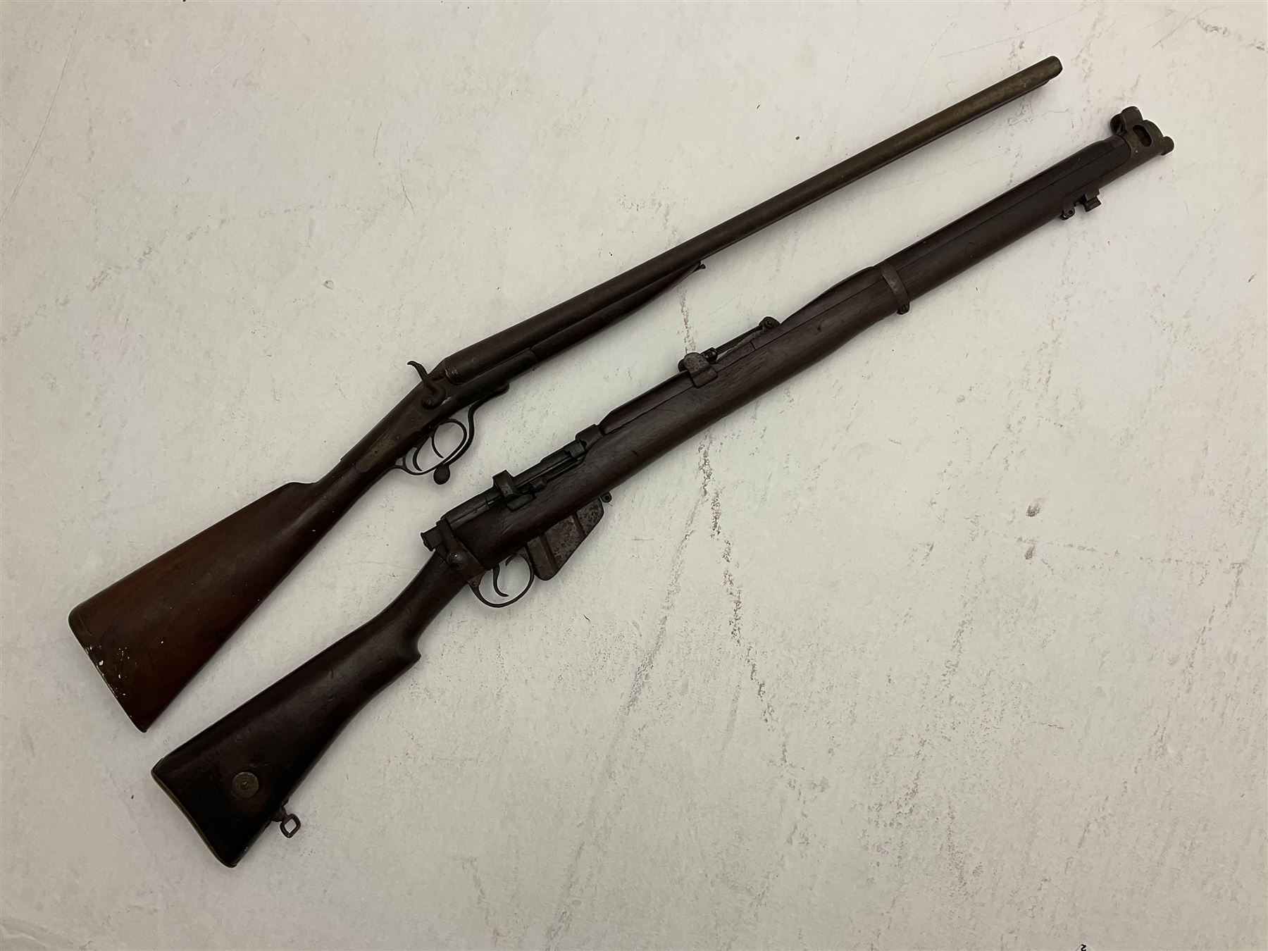 WW1 Lee Enfield SMLE .303 bolt action rifle with 63.5cm barrel and magazine; No.20934; L112cm overall; home deactivated by welding down bolt and end of barrel so requires re-deactivation to modern standards; and 19th century 12-bore double barrel hammer shotgun with 65cm cut-down barrels, non-rebounding hammers and under-lever opening, the lock-plate indistinctly inscribed G.T. Bartrant(?) L75cm overall; home deactivated by welding both barrels closed at breech so requires re-deactivation to modern standards (2) RFD ONLY 