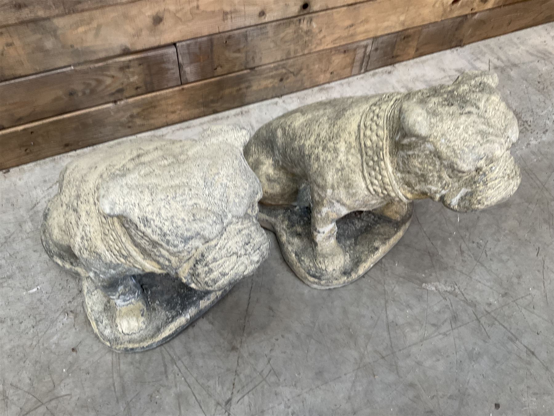 Pair of cast stone garden British bulldogs, on shaped plinths