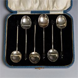 Two sets of early 20th century cased silver coffee spoons, comprising a set of six with scrolling decoration and engraved initials and a set of six coffee bean spoons, all hallmarked 