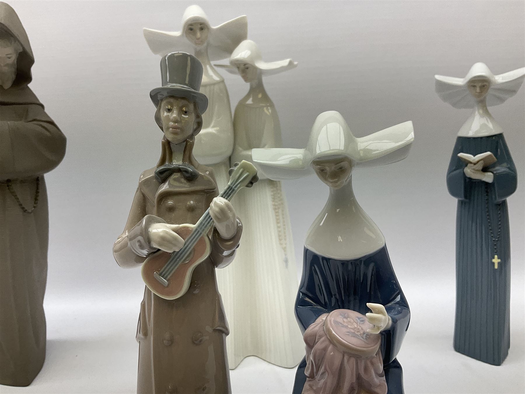 Three Lladro figures of nuns comprising Prayerful Moment no. 5500, Time to Sew no. 5501 and Two Nuns model no. 4611, together with figure of a monk no. 2060, and further Lladro bell figure