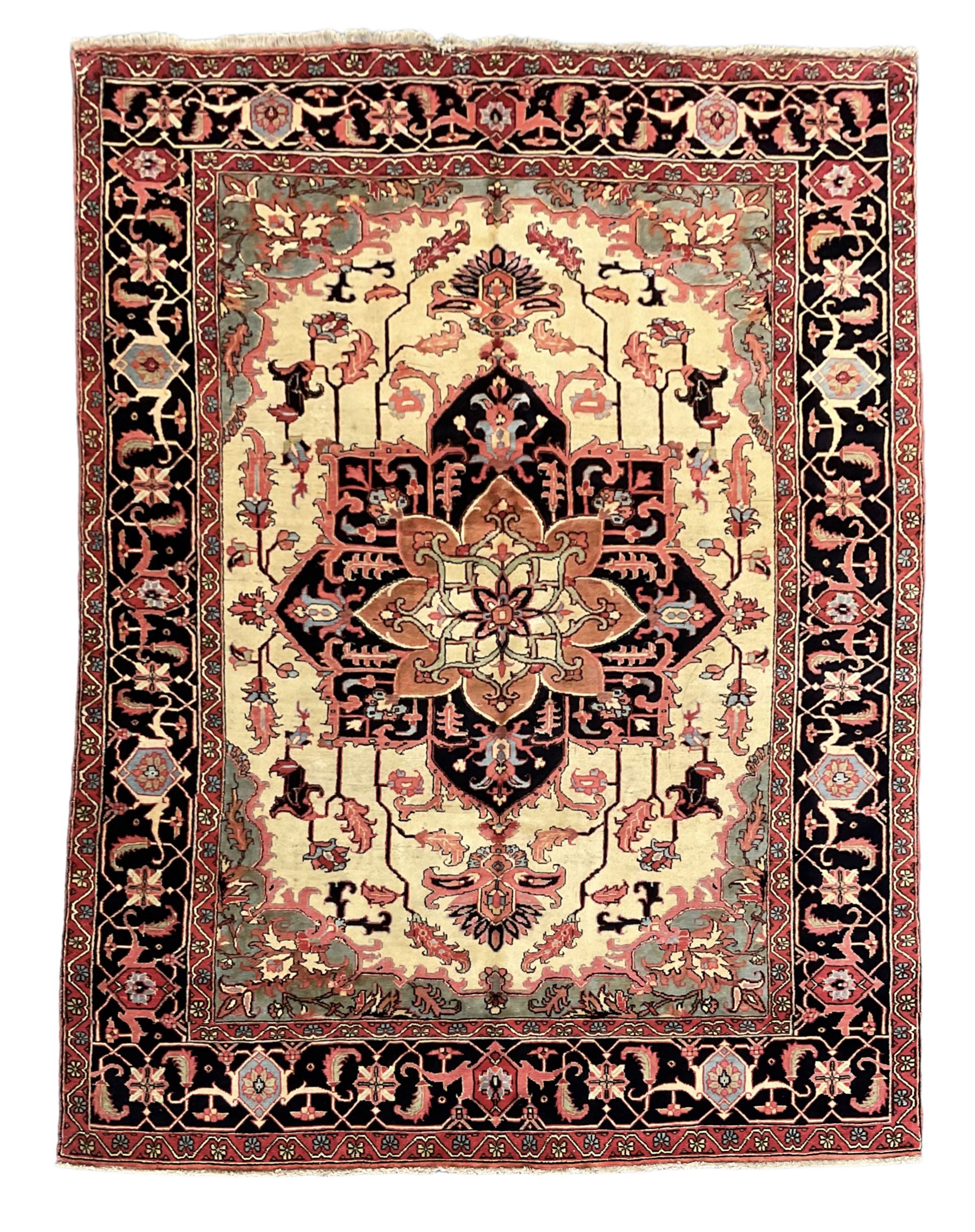 North West Persian Heriz carpet, ivory ground with large central medallion and floral spandrels, triple band border with scrolling design decorated with flower head and plant motifs 