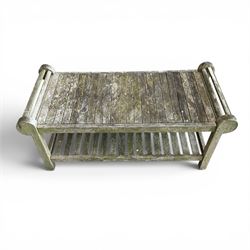 Lutyens design weathered teak garden bench with matching two-tier table, the bench with shaped arched and slatted back over rolled arms and slatted seat