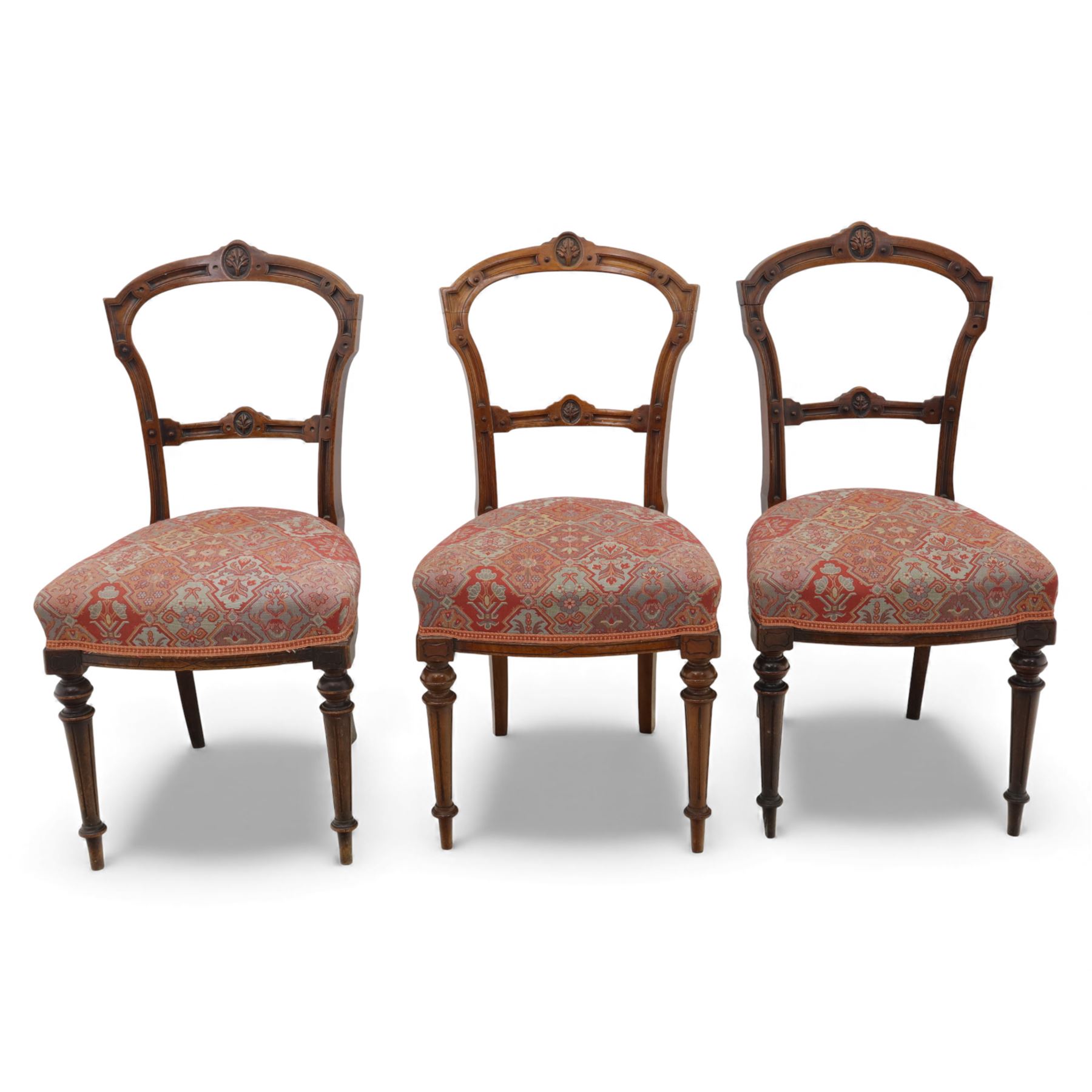 Set of six late Victorian mahogany dining chairs, the shaped top rails carved with anthemion motifs, above pierced splats, floral and geometric fabric seat, on turned and fluted front legs