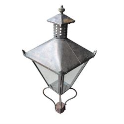 Early 20th century brass and cast iron garden lantern or street light, turned finial over four panel glazed body, cast iron base