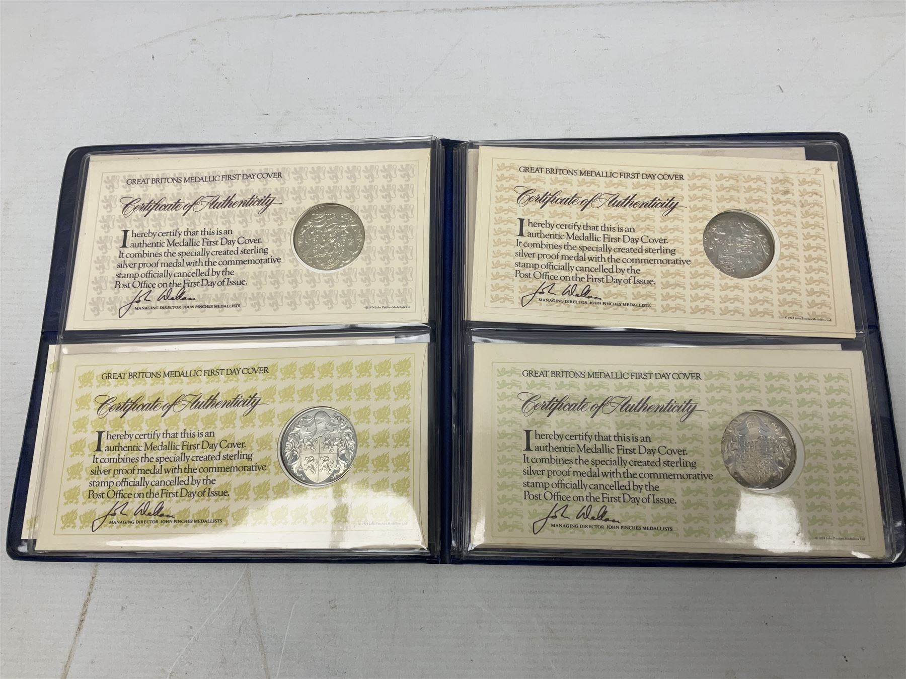 The Royal Mint United Kingdom 1984 brilliant uncirculated coin collection, 1997 and 2001 commemorative crown coins, 1997 old round one pound, all in card folders and four sterling silver medallic first day covers from the 'Great Britons' collection housed in a blue folder