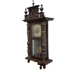 German wall clock in a mahogany vase with turned columns and finials, eight day spring driven movement striking the hours on a gong, brass dial with a silvered chapter ring, Arabic numerals and steel spade hands.