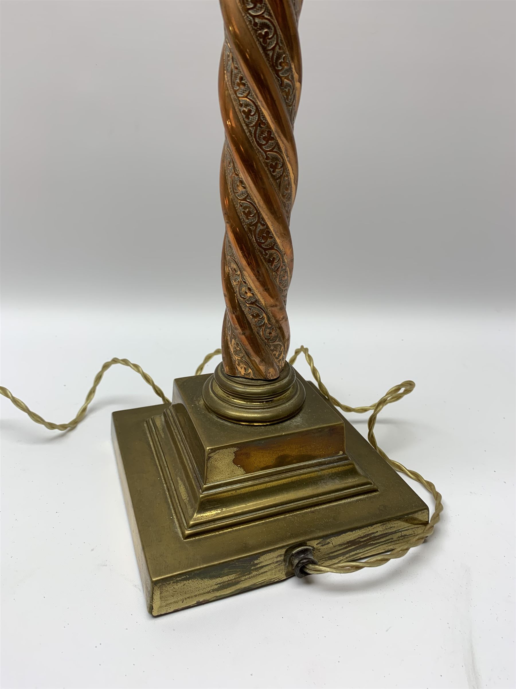 Early 20th century brass and copper Corinthian column table lamp, the square stepped brass base leading to a spiral twist copper column and brass Corinthian capital, H44.5cm 