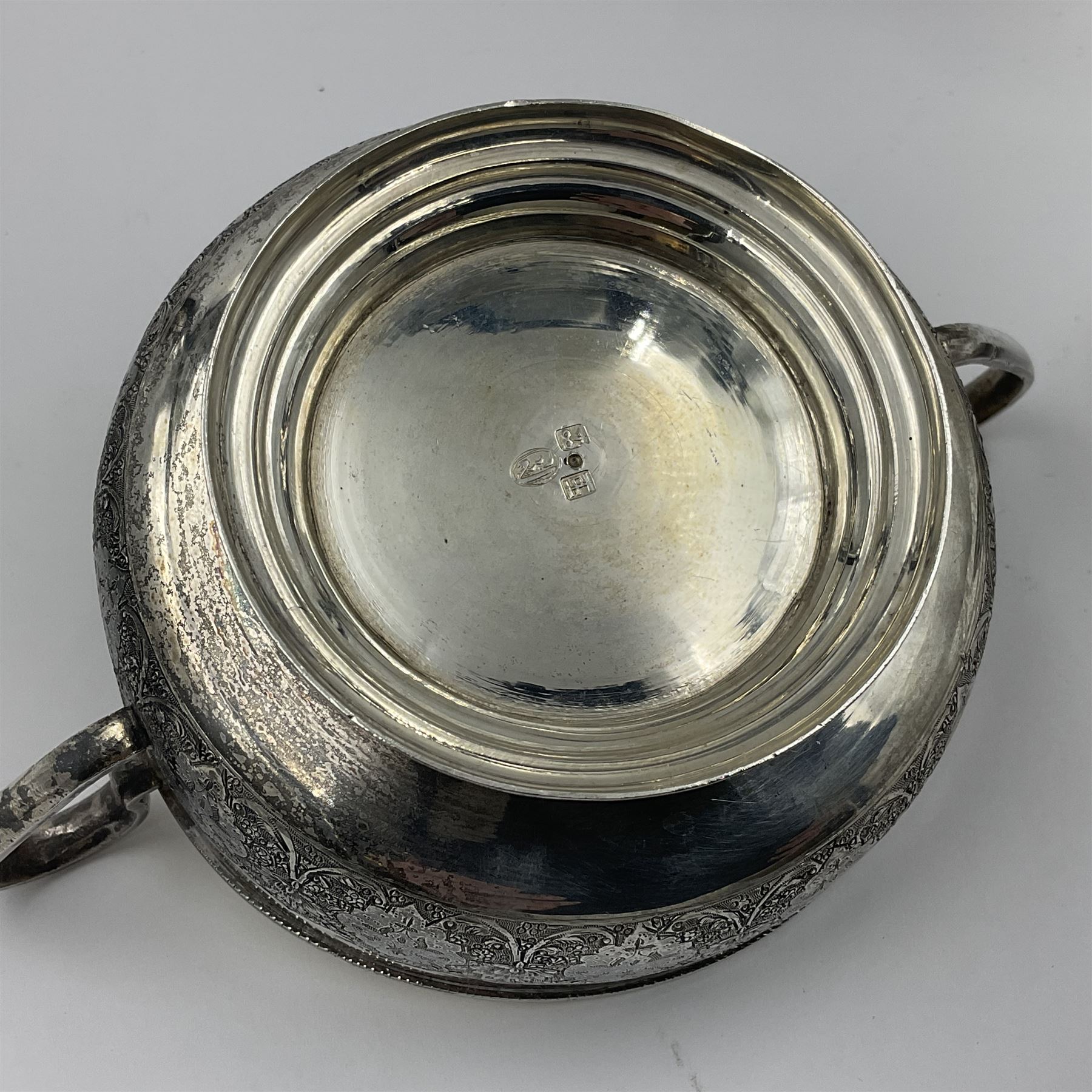Early/mid 20th century Persian silver tea service, comprising circular serving tray, teapot, twin handled sucrier and cover, milk jug, five tea glasses with six silver holders, six tea spoons, and pair of sugar tongs, each profusely chased with foliate arabesque decoration, each bearing marks including 84 for 840 fineness, tray D40cm, teapot H16cm