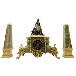 19th century green onyx and figural clock garniture, the clock set with cast and bronzed metal figure depicting an Arabian girl with a water jug on naturalistic setting, black slate Roman chapter ring, raised on gilt scrolled acanthus leaf feet and with ornate gilt metal mounts, twin train driven eight day movement striking the hours and half on bell, the movement back plate stamped ‘G.R’, together with two green onyx obelisk garnitures on square stepped gilt wood plinths with flower head roundals