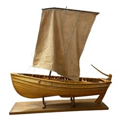 Wooden model of a fishing coble, with single canvas sail, upon a rectangular wooden plinth, total H74cm