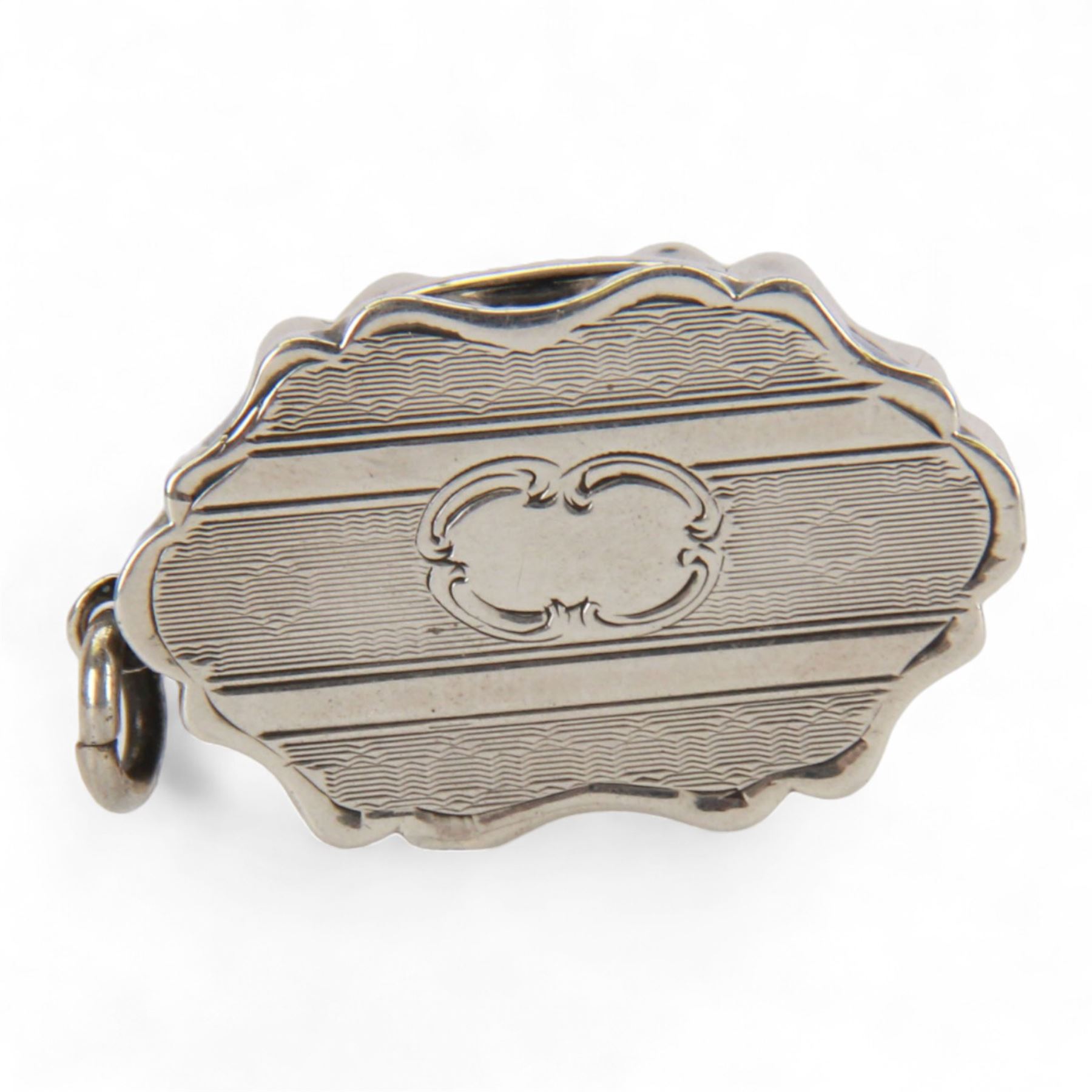 Victorian silver vinaigrette, of oval form with shaped edge, decorated throughout with engine turned bands, the hinged cover with vacant C scroll panel opening to reveal a foliate pierced grille and gilt interior, hallmarked George Unite, Birmingham 1857, L3.5cm