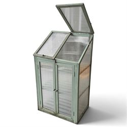Three green-painted timber cold-frame greenhouses or growhouses, each with twin hinged sloping polycarbonate lids above a pair of panelled doors enclosing slatted shelves