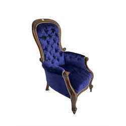 Victorian armchair, spoon back and scrolled arm terminals, upholstered in indigo buttoned velvet with sprung seat, raised on cabriole supports on castors