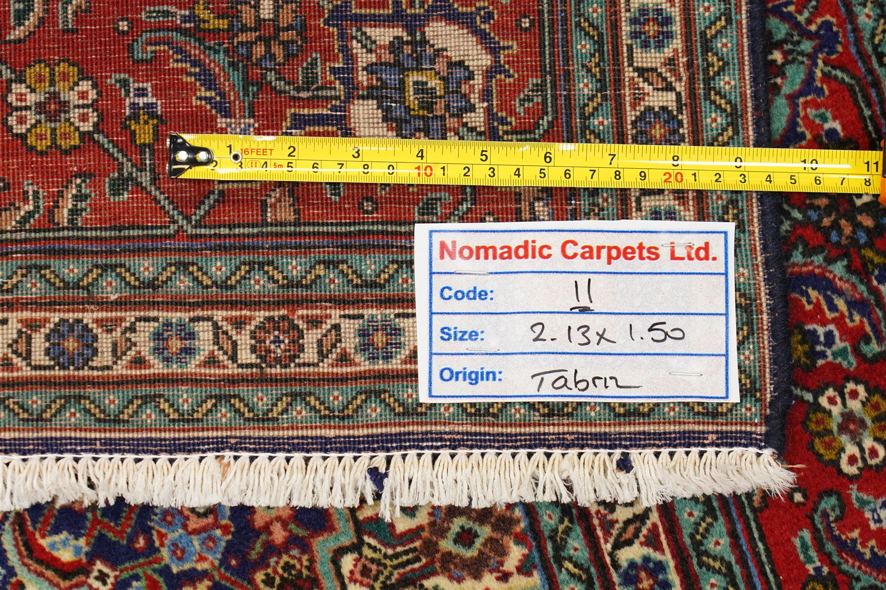 North West Persian Tabriz hand-knotted rug, ivory field with a central lozenge medallion in deep indigo and madder red, enclosing a inner reserve with stylized floral motifs, spandrels with angular floral sprays, main border of repeating floral vinery and palmettes, framed by multiple guard borders, with cotton fringe ends