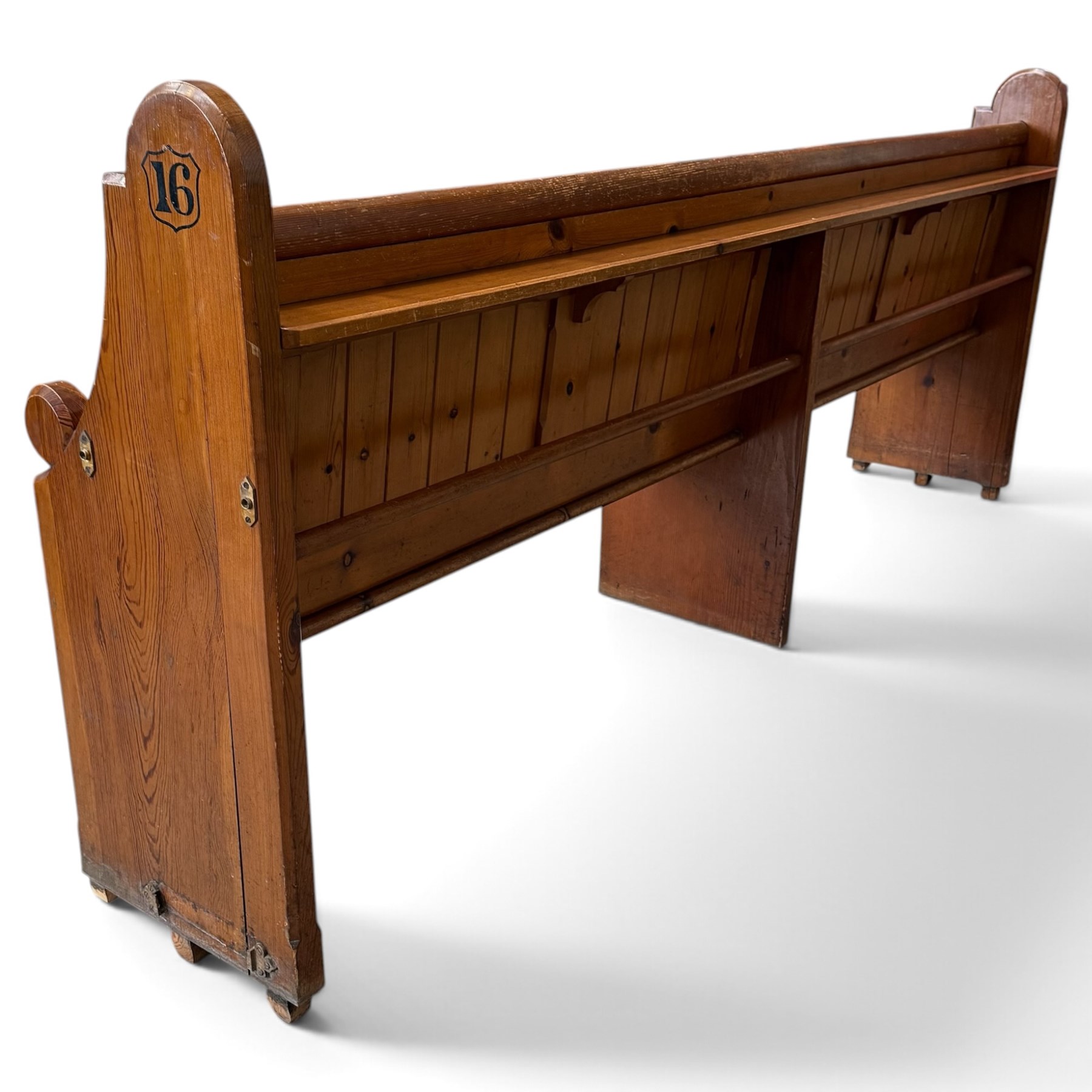 Early 20th century stained pine ecclesiastical church pew, the shaped end supports flanking slatted and panelled back, with black stencilled number '16' to the side