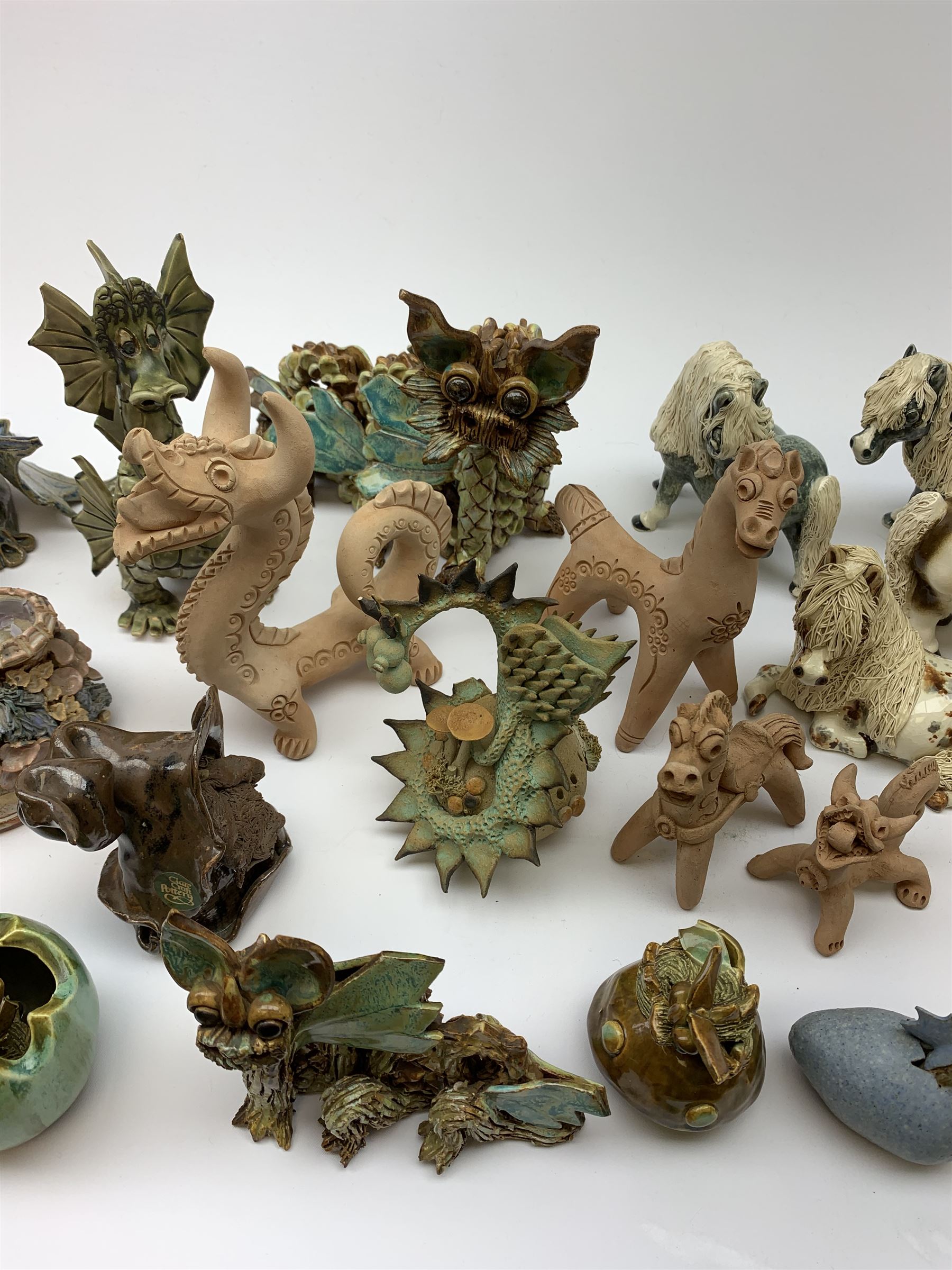 Four Cheval Ceramics figures modelled as ponies, together with a number of studio pottery figures of dragons. 