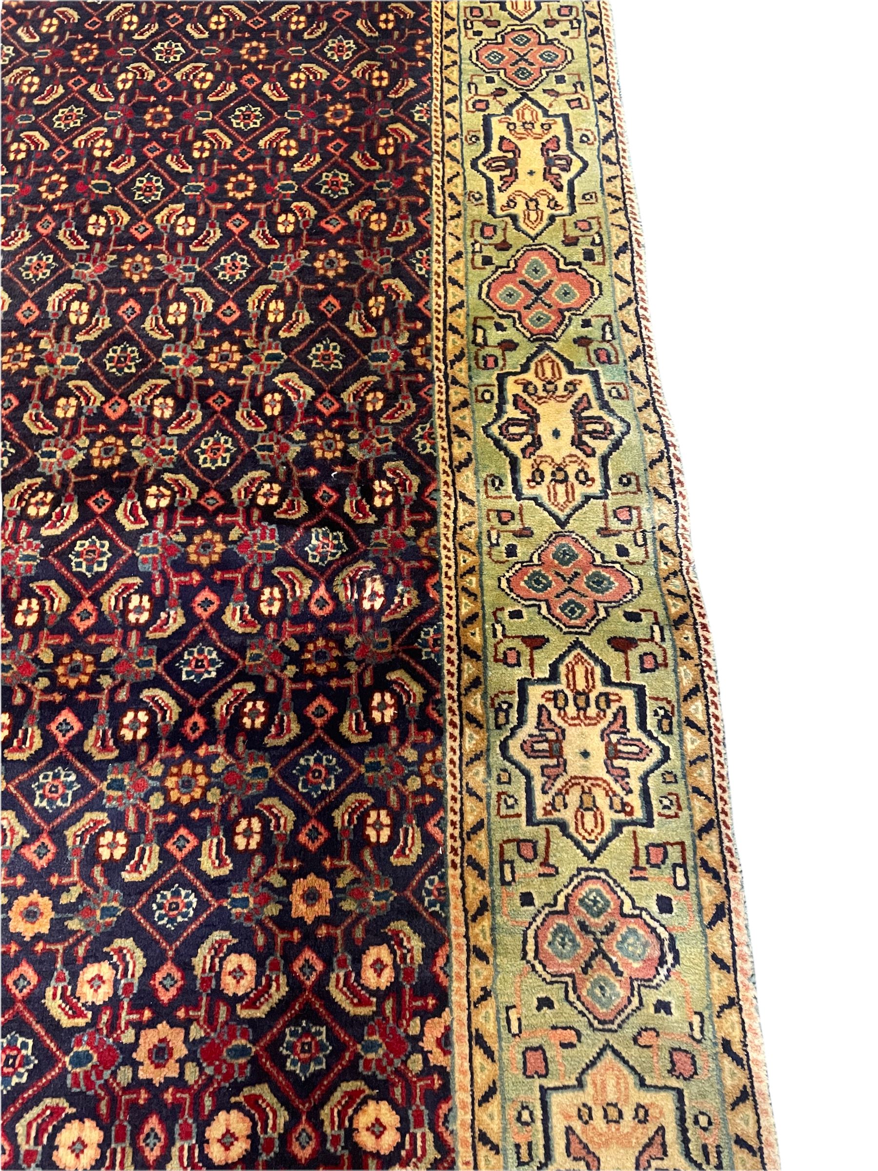 Persian Mahal rug, the blue ground field decorated with repeating Herati motifs, guarded pale ground border decorated with stylised panels