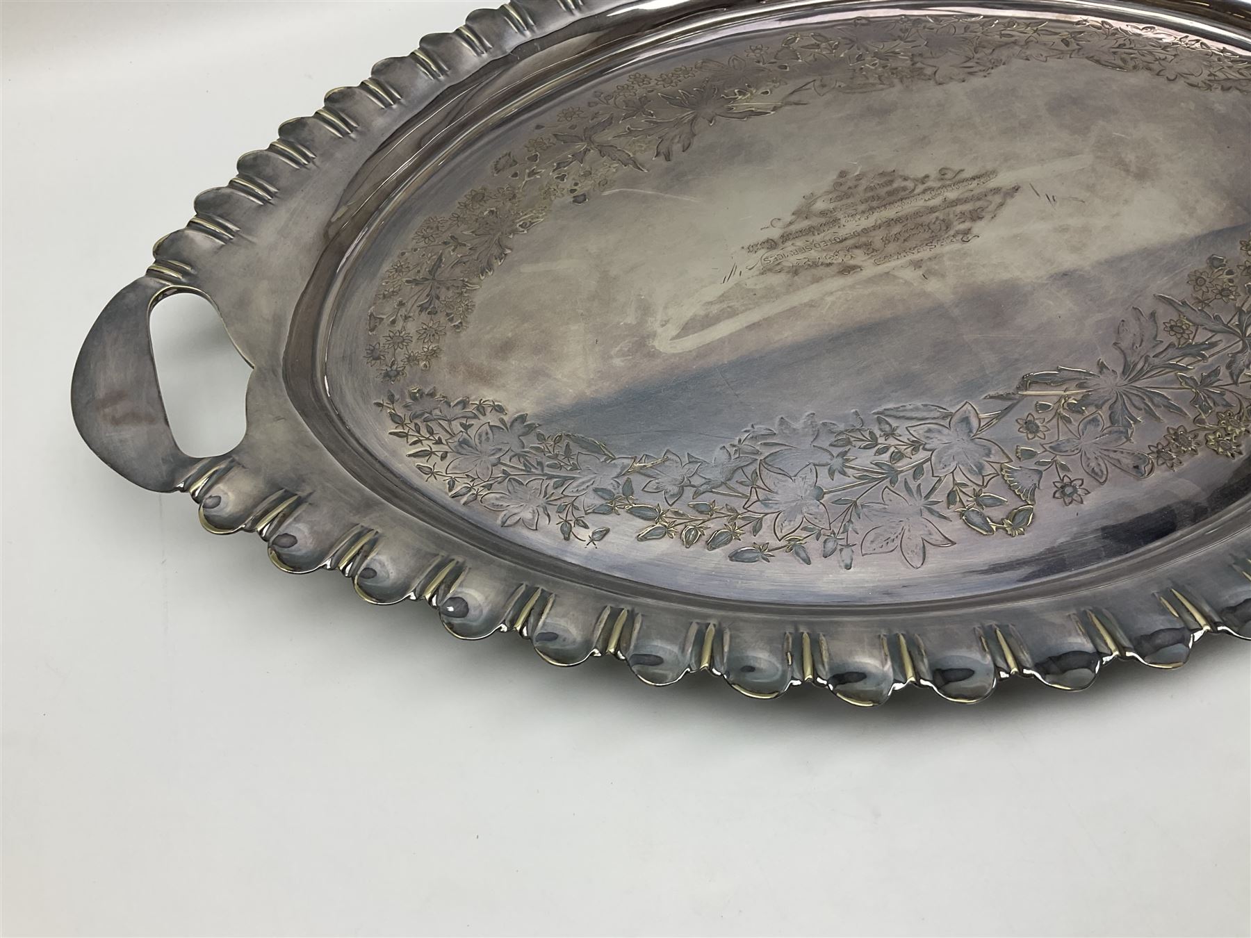 Oval silver plate twin handled tray, egg and dart edge, engraved with floral springs surrounding an central inscription, L65cm
