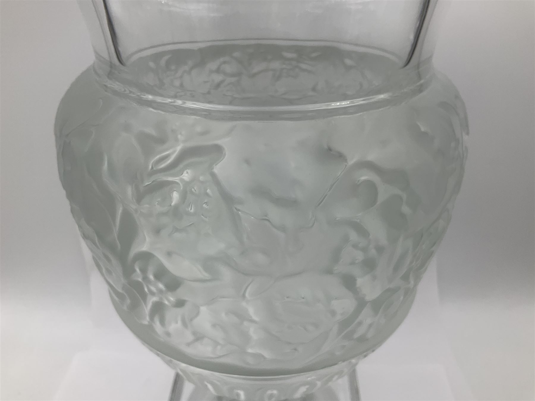 Large and impressive Lalique Versailles pattern glass vase, of classical baluster form with gadrooned flared rim, the body moulded in relief with fruiting vines above part fluting, upon a spreading circular foot with moulded decoration, and plain square plinth base, signed Lalique France to side of plinth, overall H35cm, with original box 