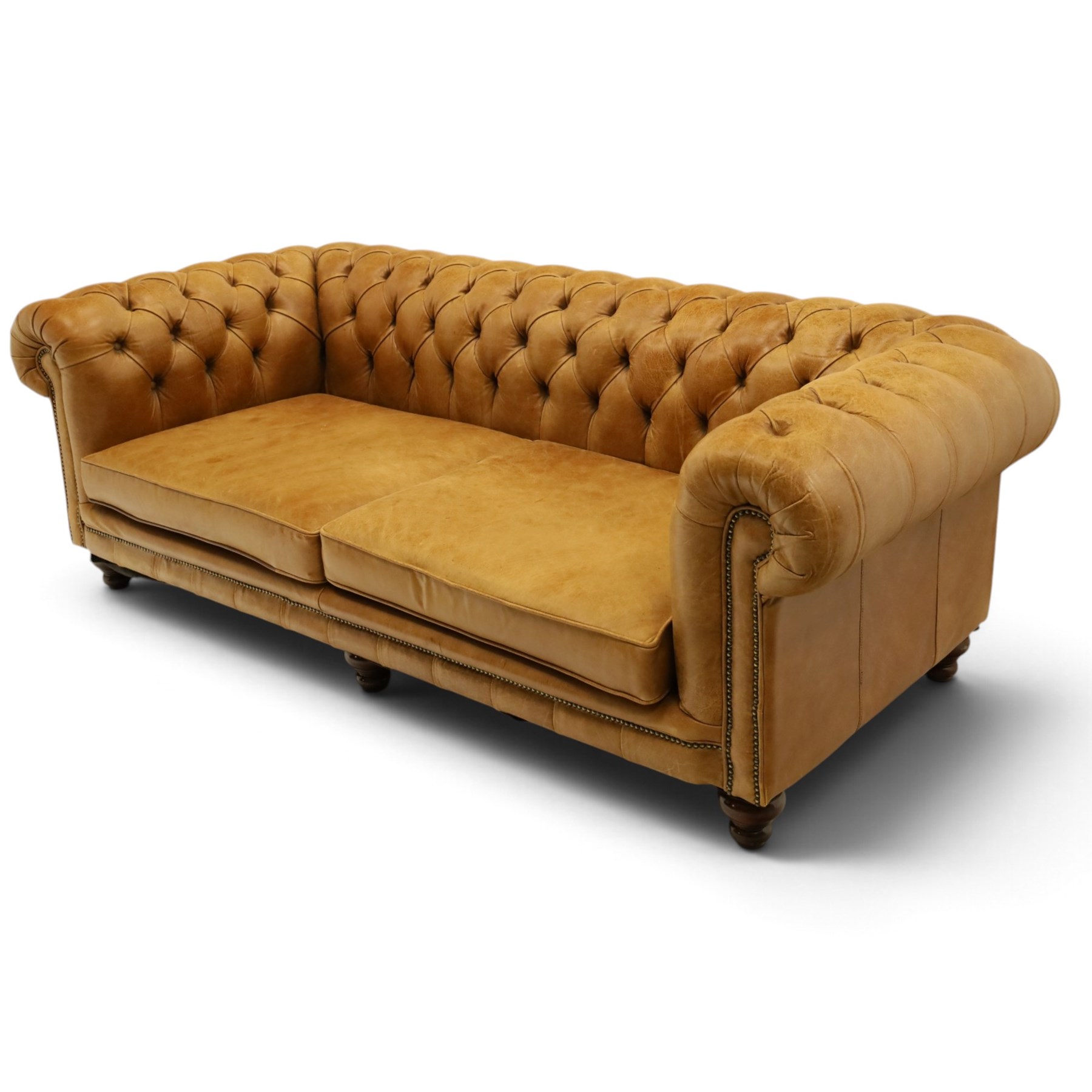 Distinctive Chesterfields - traditional shape four seater Chesterfield sofa, the rolled back and arms upholstered in deep-buttoned tan leather with matching loose seat cushions, raised on six turned supprorts