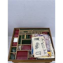 Large collection of Meccano, including perforated strips, wheels, cogs, nuts and bolts, various Meccano instruction manuals and magazines, all housed within a modified wooden box, with three tiered compartmentalised sections and upon four twist legs, box H60cm