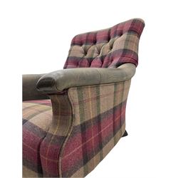John Sankey - low armchair, buttoned back upholstered in tartan patterned fabric with contrasting grey leather, raised on turned and ebonised front feet with brass and ceramic castors, with matching foot stool