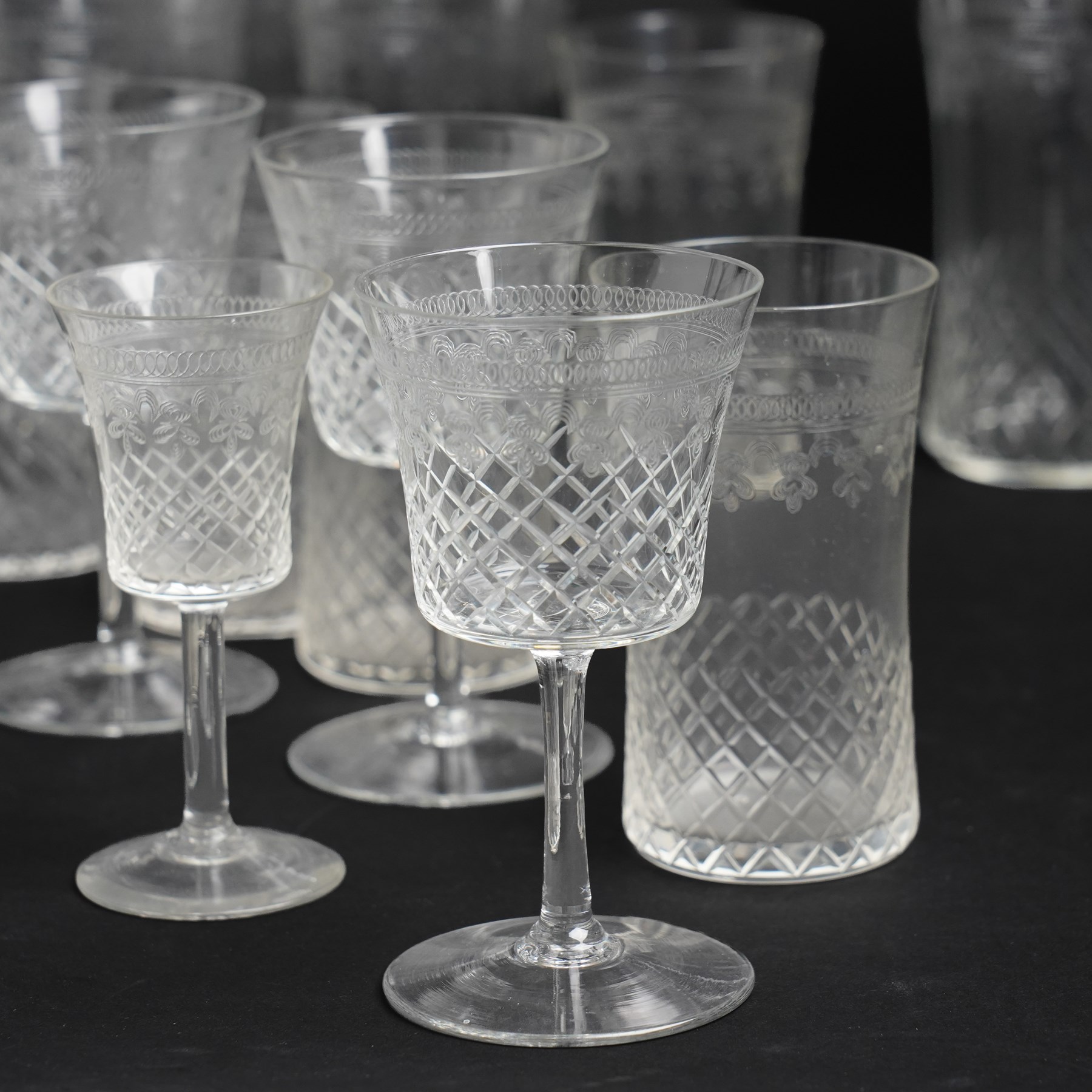 Suite of early 20th century cut and etched table glass comprising nine tumblers, ten smaller tumblers, eleven small wine glasses, six sherry glasses and water jug together with four other sherry glasses