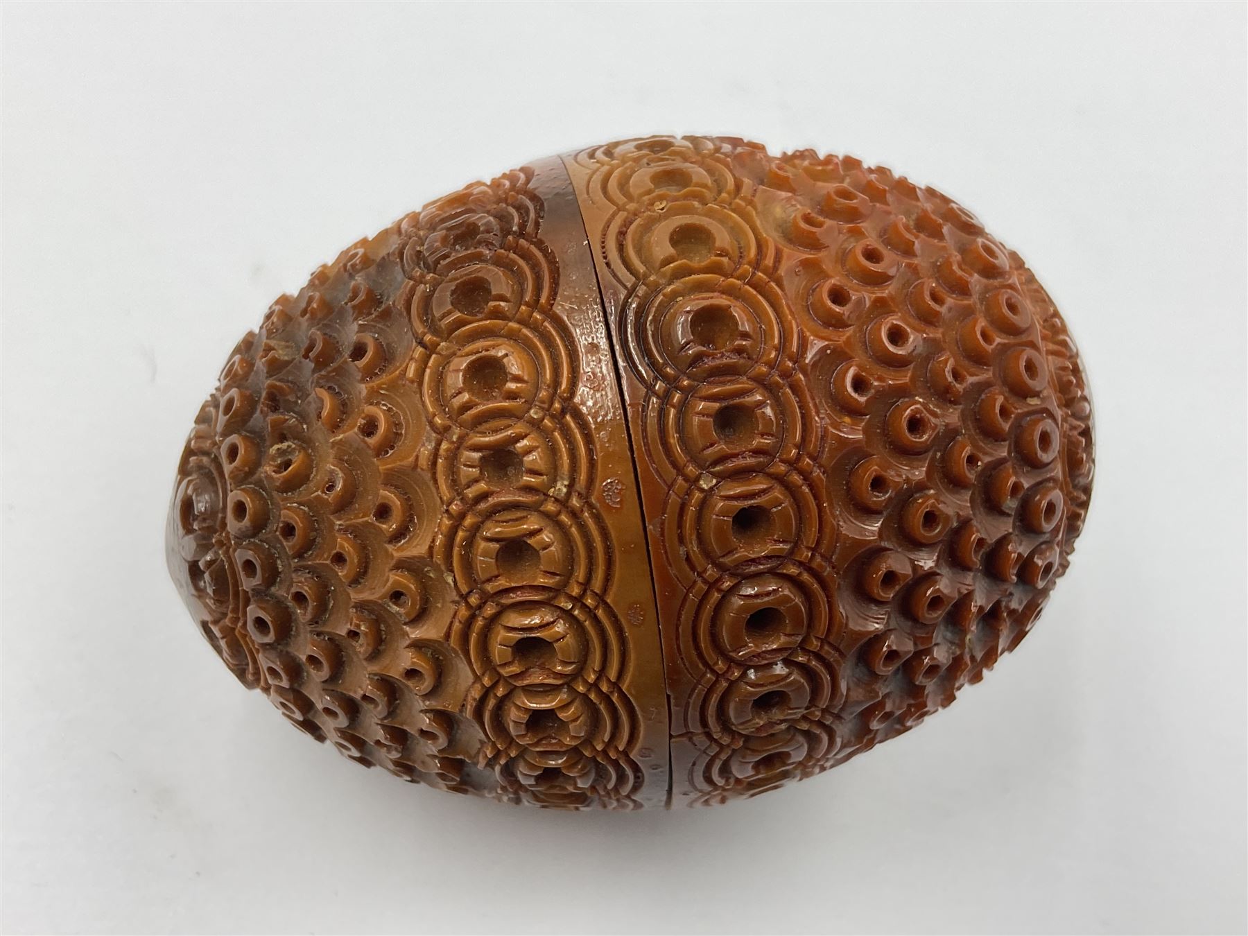 Three 19th century coquilla nut pomanders or flea catchers, two of egg shaped form and the third of barrel from with carved and pierced decoration and screw threaded join, largest H8cm