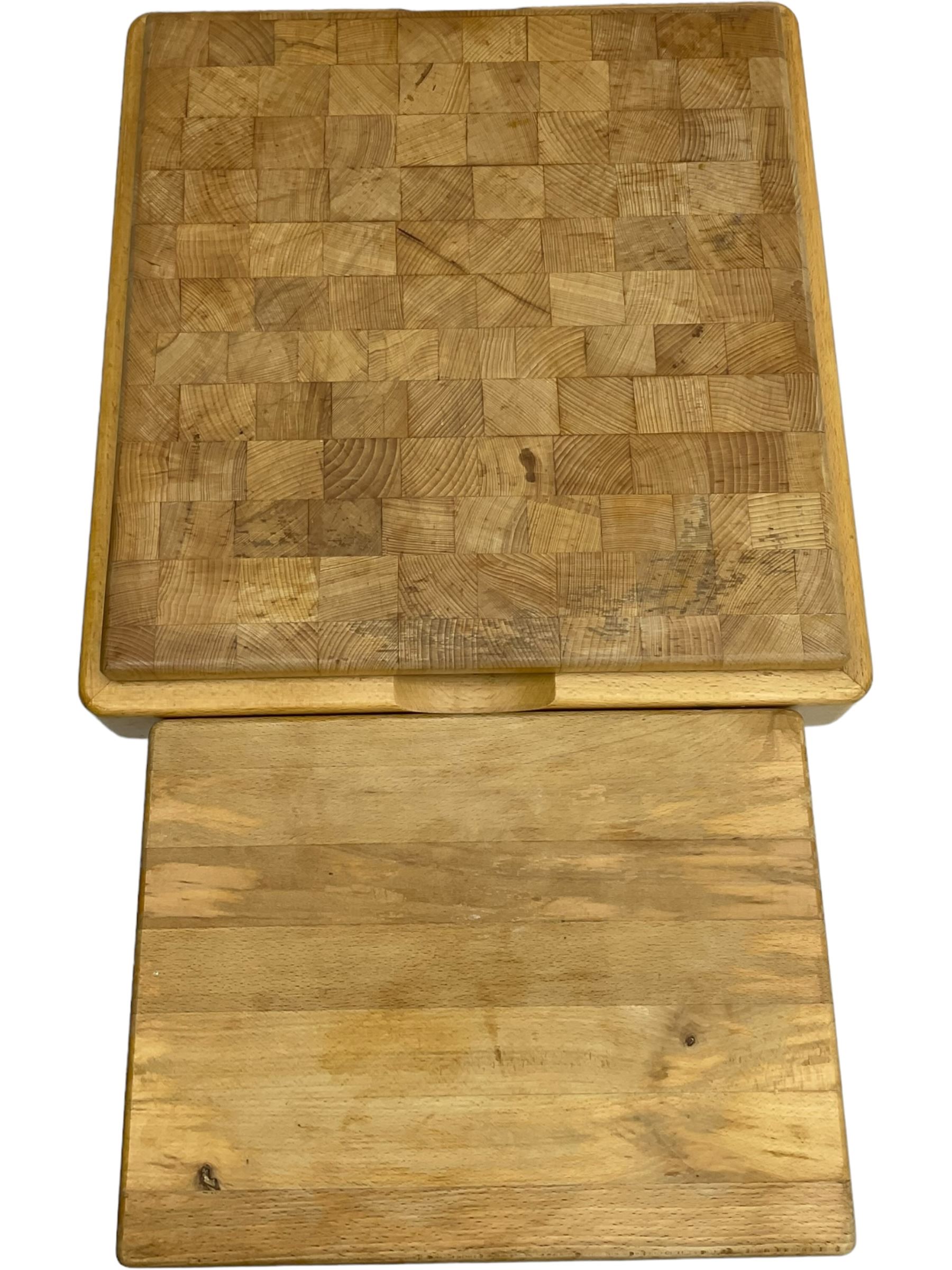 Beech butcher block kitchen cart, featuring square butcher block top, side drop-leaf extension, single drawer with metal sides, and two slatted shelves below, the cart supported by four castors