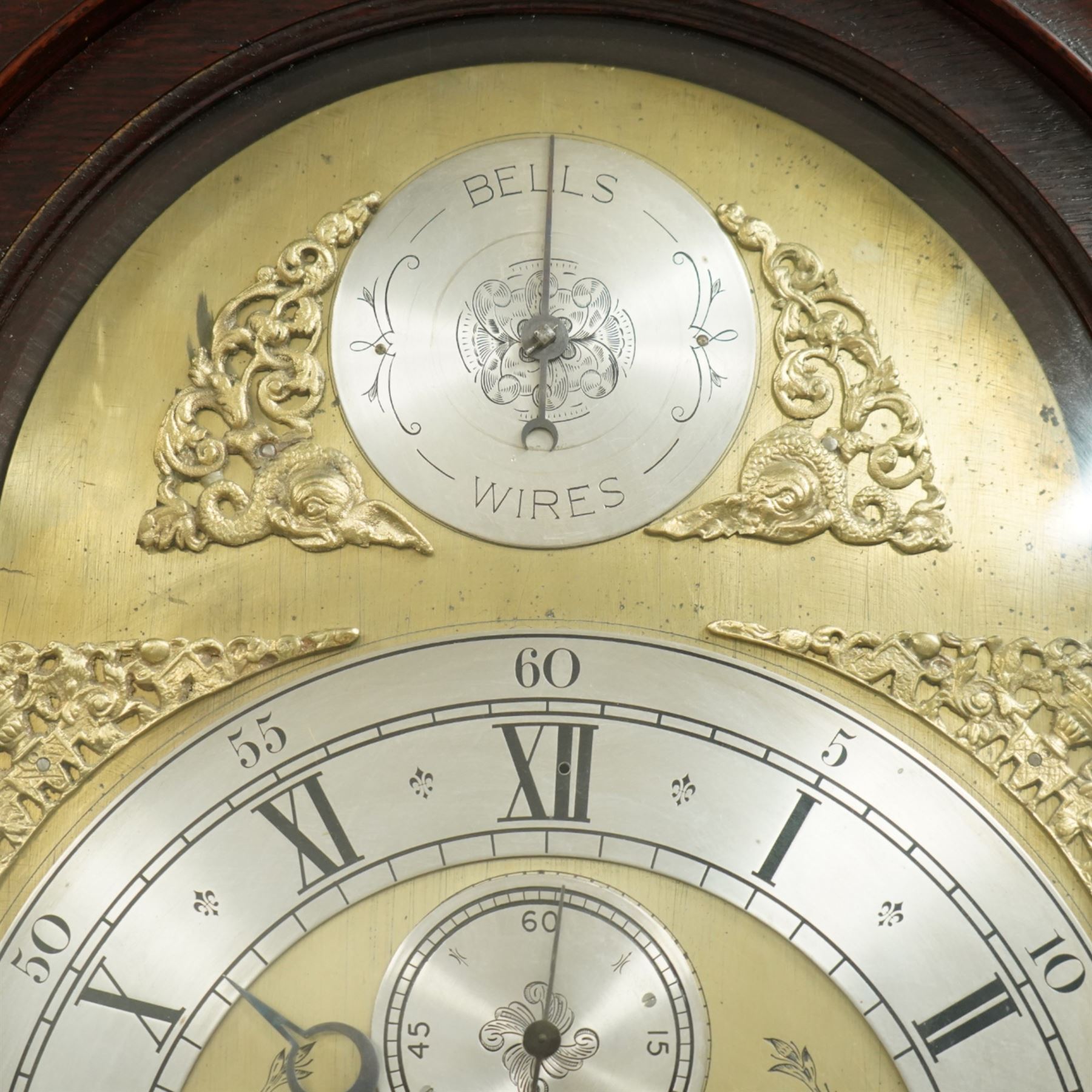 Lister of Halifax -  Oak cased musical longcase clock c1790, 8-day movement sounding the quarters and hours on bells or gong rods, case with a flat pediment and oval  conch inlay beneath, break arch hood door with reeded pilasters and brass Corinthian capitals, trunk with conforming quarter recessed pillars and a long wavy topped door, plinth with a raised panel and applied moulding the the base, break arch brass dial with cast spandrels and engraved dial centre, with a silvered chapter, seconds dial and cartouche with makers name, gongs or bells selector to the arch, chapter with Roman numerals, five minute Arabic's, minute track and steel moon hands, dial pinned directly to a three train weight driven movement with a nest of eight bells and eight gong rods, sounding the hours on either bells or gong rods, with a rack strike and recoil anchor escapement. With pendulum and weights.
The Lister family were a prodigious family of prolific clockmakers working in Halifax and the West Riding area of Yorkshire during the 18th and 19th century, well-known and noted for producing a number of chiming and musical longcase clocks.