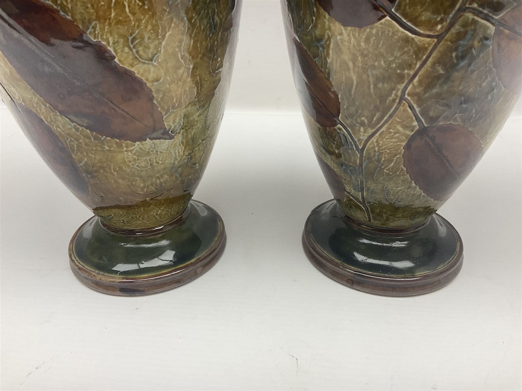 Pair of Royal Doulton Stoneware Vases with leaf decoration, by Ethel Beard, impressed marks to base numbered 6768 and 8222 and initials EB, H32cm
