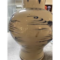 Pair of Chinese Kangxi blue and white porcelain vases, each of baluster form, painted with an outdoor scene containing figures seated upon the ground reading scrolls and holding fans, willow and bamboo tress, rock work and water, H27cm