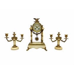 A late 19th century French portico clock with a pair of matching double light candelabra, eight-day outside countwheel movement with recoil escapement, backplate stamped “A.D. Mougin, Paris”, striking the hours and half-hours on a bell, foliate cast bezel with bevelled convex glass, white enamel dial with upright Arabic numerals and minute track, floral garlands and gilt Louis XV hands, gilt drum case surmounted by a small ormolu bird taking flight, raised on four ringed pillars with ornate capitals on a stepped white marble plinth with ormolu mounts, paw feet and gadroon border, pendulum bob with a decorative sunburst mask, pair of matching single column candelabra on a circular marble plinth with two festooned scroll branches and lights plus ormolu mounts and swags. 