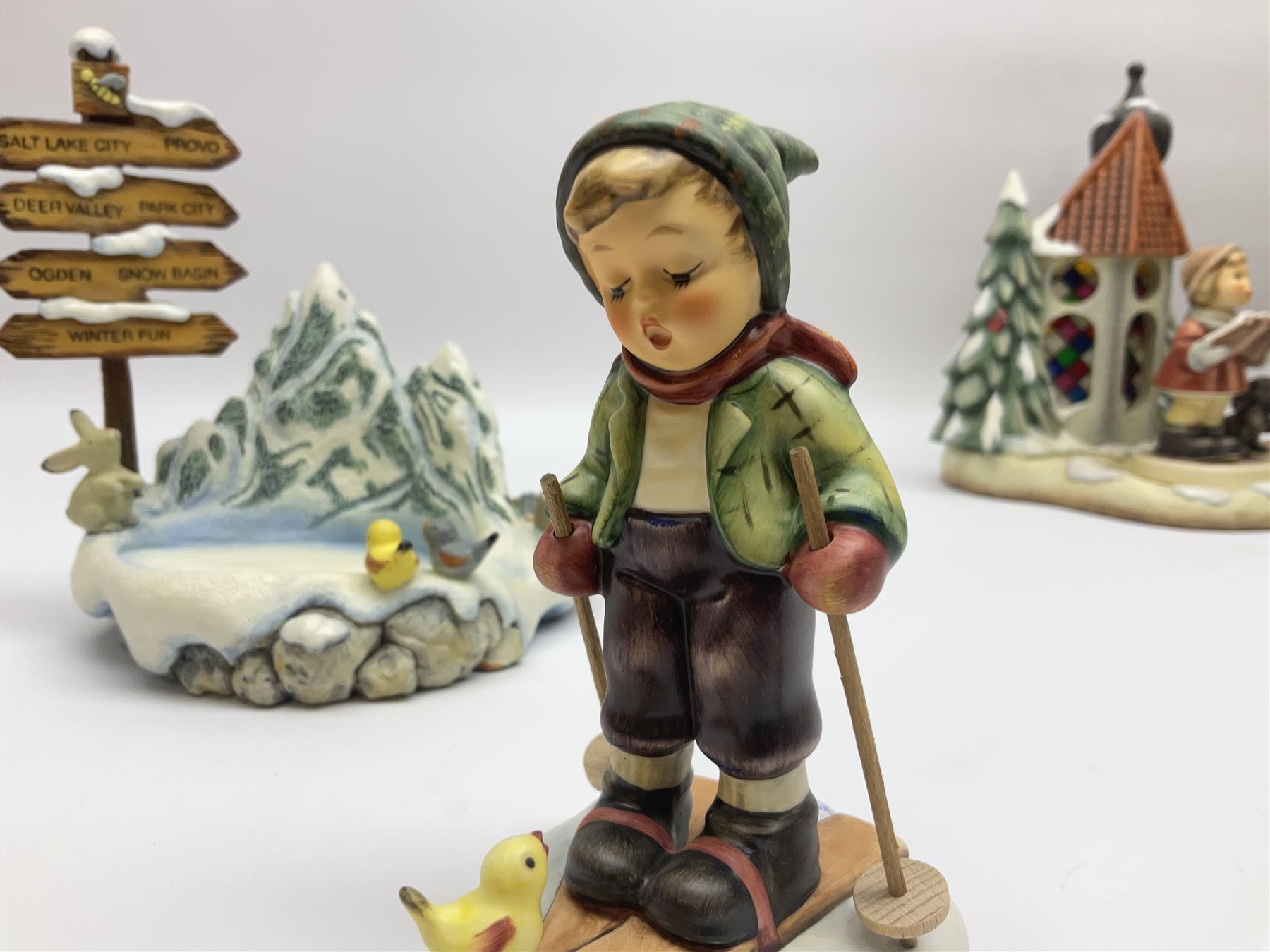 Eight Christmas Hummel figures by Goebel, to include Wintertime Chapel candle holder, Winter Fun, Christmas Morning, Christmas Time and Gingerbread Lane, tallest H21cm