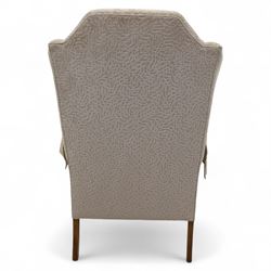 Late 20th century wingback armchair, upholstered in beige embossed fabric with brass stud edging, on cabriole legs and splayed rear legs