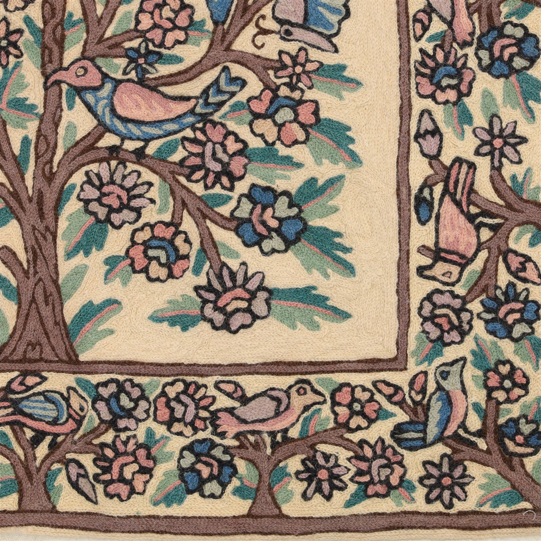 Kashmiri chain stitch crewel embroidered wall hanging, the tree of life design embroidered on a cream ground with coloured pastel tones of rose, teal blue, and light brown in an arched mihrab style framing 